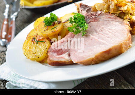 Un tipico piatto bavarese: cotte spareribs di maiale con cavolo bavarese e patate fritte Foto Stock