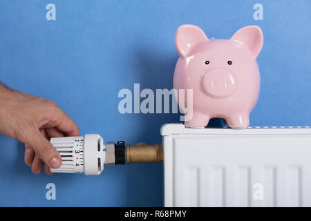 Man mano del termostato di regolazione Foto Stock