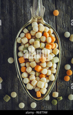 Cucchiaio di couscous crudo su uno sfondo di legno Foto Stock