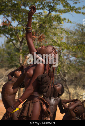 Tribù Himba giovane donna guardando un drone nel cielo, Provincia del Cunene, Oncocua, Angola Foto Stock