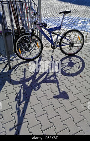 Una bicicletta parcheggiata e la sua ombra su una strada a Sofia, la capitale della Bulgaria Foto Stock