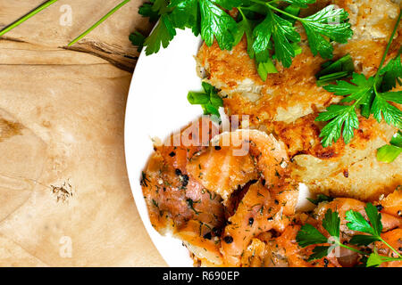 Frittelle di patate con Salmone. Frittelle di verdure con pesce. Latkes su una piastra Foto Stock