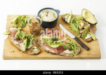 Cipolla rustico pane con formaggio fresco prosciutto di Parma Avocado Rucola Timo peperoncino e pomodoro Foto Stock