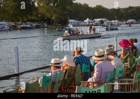 Gli spettatori seduti in steward' involucro a Henley Royal Regatta come arbitro il lancio passa alla fine di una gara. Foto Stock