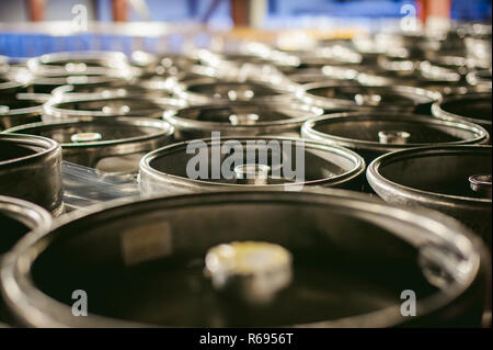 La birra in fusti. Molti metallico barile di birra stand in righe in un magazzino Foto Stock