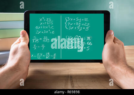 Persona in possesso di Tablet con equazioni matematiche sullo schermo Foto Stock