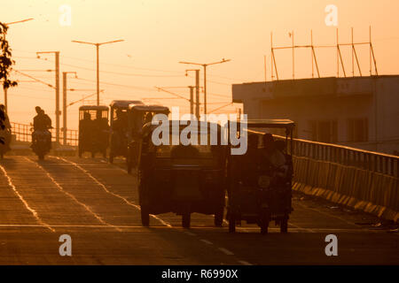 Risciò motorizzati e il traffico sul cavalcavia al tramonto a Jaipur, Rajasthan, India Foto Stock