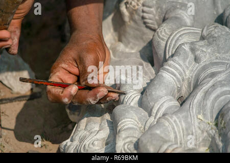 Una stone mason scalpelli i tocchi di rifinitura per i suoi religiosi indù stone carving. Foto Stock