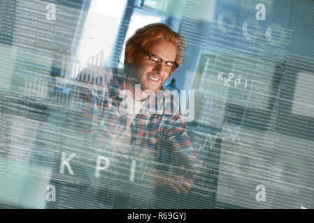 Tagliate il colpo di un felice sviluppatore computer la scrittura del codice in bicchieri Foto Stock
