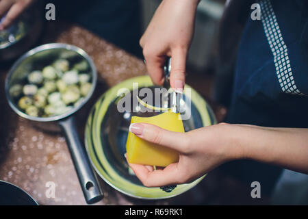 Merchant per affettare il formaggio utilizzando speciali Coltello per formaggio- formaggio piano. Chiusura del formaggio da taglio sulla strada del mercato. Foto Stock