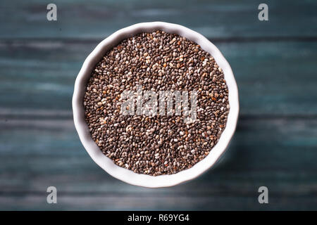 La quinoa grano in una ciotola di legno verde dello sfondo. Foto Stock