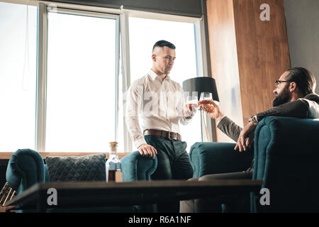 Due partner commerciali di bere alcolici dopo una lunga giornata di lavoro Foto Stock