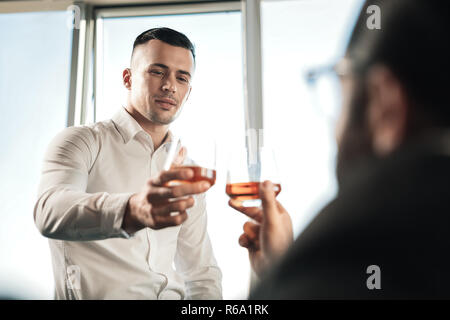 Due partner commerciali a bere del cognac dopo la conclusione positiva dei negoziati Foto Stock