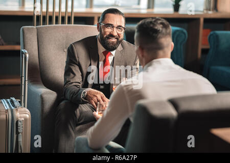 Due proprietari di bere whisky in hotel lobby avente per un viaggio di lavoro Foto Stock