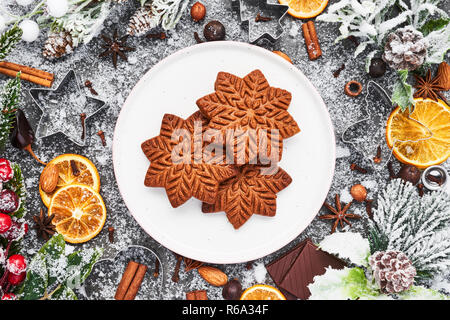 Vacanze sfondo di cottura. Natale gingerbread cookies con frese e spezie in calcestruzzo di colore grigio nella tabella. Gastronomia natalizia. Vista dall'alto. Foto Stock