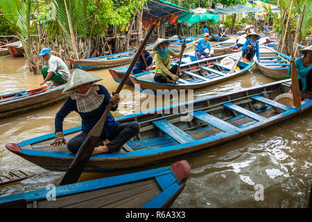 MY THO, VIETNAM - Novembre 24, 2018: Fiume Mekong Delta crociera nella giungla con artigiani non identificato e fisherman barche a remi per le inondazioni fangoso lotus fi Foto Stock