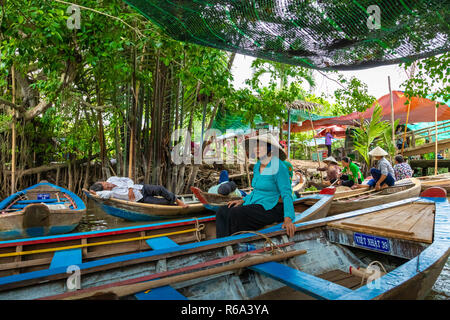 MY THO, VIETNAM - Novembre 24, 2018: Fiume Mekong Delta crociera nella giungla con artigiani non identificato e fisherman barche a remi per le inondazioni fangoso lotus fi Foto Stock