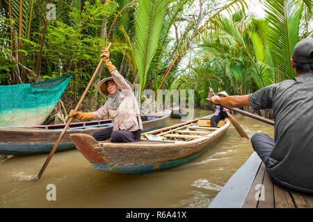 MY THO, VIETNAM - Novembre 24, 2018: Fiume Mekong Delta crociera nella giungla con artigiani non identificato e fisherman barche a remi per le inondazioni fangoso lotus fi Foto Stock