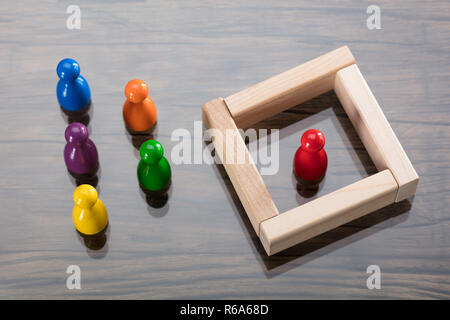 Multi colore pedina di figurine e blocchi di legno sulla scrivania Foto Stock