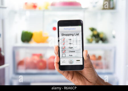 Mano umana marcatura Shopping List sul telefono cellulare Foto Stock