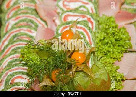 Piatto con salmone affumicato rotoli guarnita con lattuga e Physalis Foto Stock