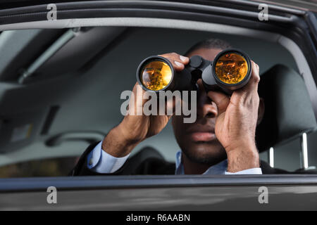 L'uomo africano guardando attraverso il binocolo Foto Stock