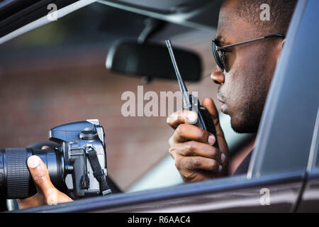 Detective seduto all'interno dell'auto Foto Stock
