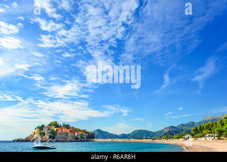 Sveti Stefan isola in Budva con una spiaggia in una bella giornata estiva, Montenegro. destinazione di viaggio Foto Stock