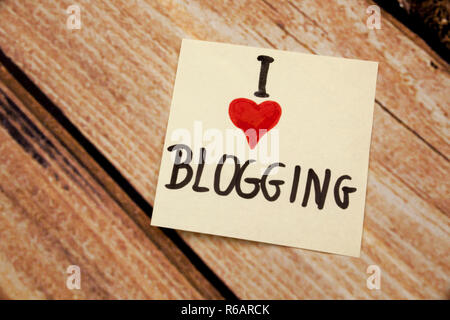 Io amo i blog scritti a mano con il bianco stiky nota su un sfondo di legno Foto Stock