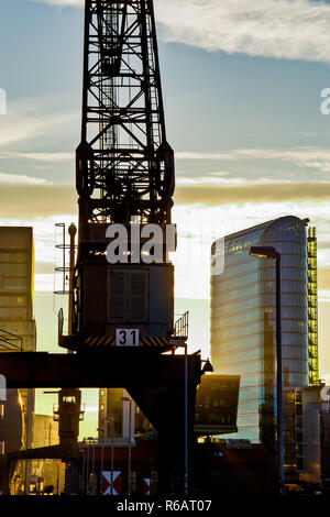 Im Gegenlichtaufnahme Medienhafen Düsseldorf im Vordergrund ein Hafenkran und im Hintergrund das Bürogebäude segno! Vom Architekten Helmut Jahn, 2015. Retroilluminazione shot in Media Harbour Dusseldorf in primo piano di una gru del porto e sullo sfondo la costruzione di ufficio segno! Dall architetto Helmut Jahn, 2015. Foto Stock