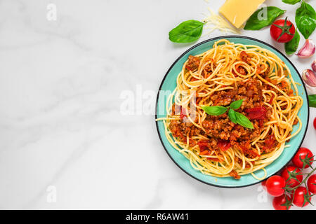 Pasta spaghetti alla bolognese su una piastra blu su bianco tavola di marmo. cibo sano. vista da sopra con lo spazio di copia Foto Stock