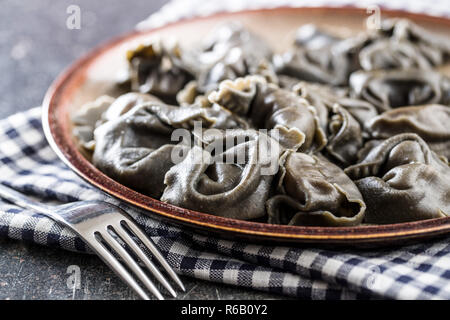 Inchiostro di calamari tortellini sulla piastra. Foto Stock