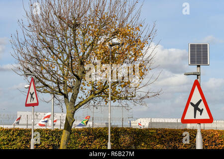 Londra, Inghilterra - Novembre 2018: cartello stradale sulla A30 Road a Londra Heathrow Airport gli automobilisti di avvertimento di bassa aeromobile in volo. La luce per il segno Foto Stock