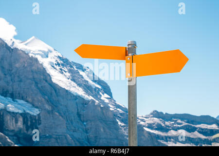 Direzione della freccia a firmare con la montagna innevata Foto Stock