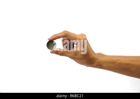 Un ritagliato di man mano che trattiene il tappo della bottiglia contro uno sfondo bianco. Foto Stock
