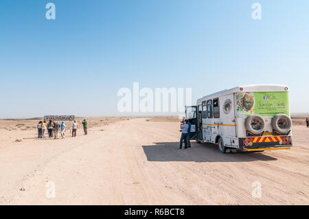 Tourist van in C14 strada di ghiaia, fare fotografie al Tropico del Capricorno segno nelle vicinanze, Namibia Foto Stock