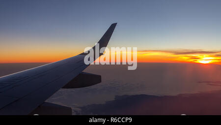 Sunrise vista dall'oblò di un aereo durante un viaggio. Foto Stock