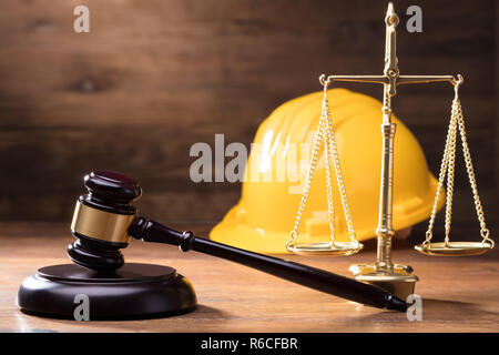 Martello di fronte giallo casco di sicurezza e scala dorata Foto Stock