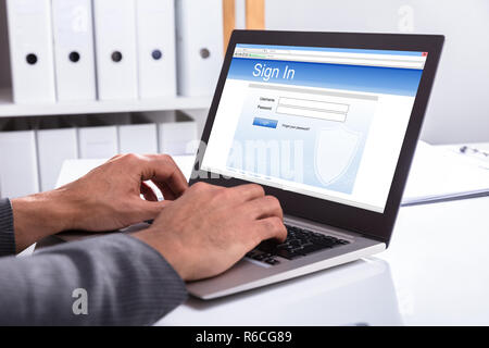 I mediatori accedendo al sito Web sul computer portatile Foto Stock