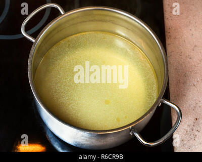 Grasso limpido brodo di manzo in pentola in acciaio Foto Stock