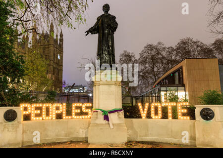 Westminster, Londra, Regno Unito. 4 Dic 2018. I manifestanti hanno posto il voto popolare in lettere alla statua di suffragette Emmeline Pankhurst. Anti-Brexit manifestanti da Sodem (Stand di Defiance Movimento europeo) hanno portato lettere luminose compitazione 'voto popolare' per punto di riferimento siti vicino le Case del Parlamento di porre con e la protesta. Credito: Imageplotter News e sport/Alamy Live News Foto Stock