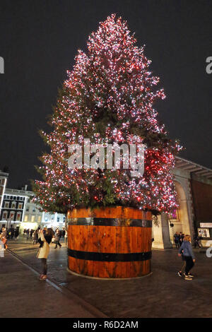 Un enorme albero di Natale visto intorno a Londra il mercato di Covent Garden e piazza. Foto Stock