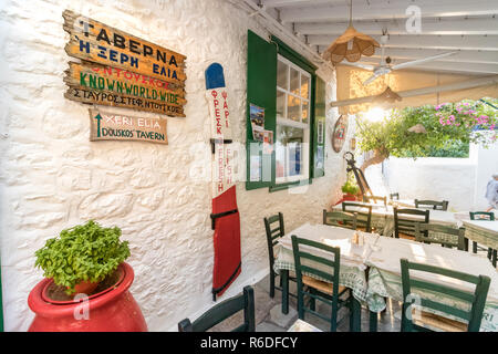 Hydra, Grecia - Ottobre 4th, 2018: una tradizionale taverna greca con legno sedie di verde nel centro della città, Hydra, Grecia. Foto Stock