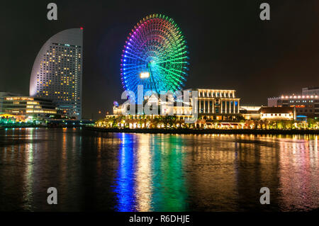 Illuminata di notte la scena di Shinko Area nel Minato Mirai 21 distretto di Yokohama, Giappone compreso il Cosmo World Parco divertimenti Foto Stock