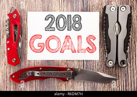 Mano concettuale di scrittura di testo Didascalia ispirazione mostra 2018 Obiettivi. Il concetto di business per la pianificazione finanziaria, la strategia aziendale scritto su una nota adesiva sullo sfondo di legno con coltello da tasca Foto Stock