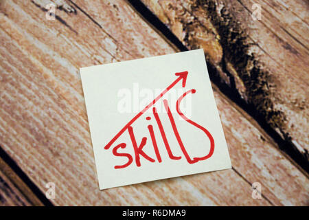Competenze scritto su una nota adesiva sul tavolo di legno per migliorare le tue competenze Concept Foto Stock