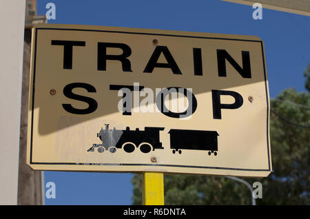 Cartello stradale con la scritta in inglese 'arresto del treno" e il simbolo della locomotiva nero Foto Stock