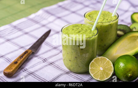 Frullato di verde su sfondo bianco con avocado, Limone sul lato destro. Foto Stock