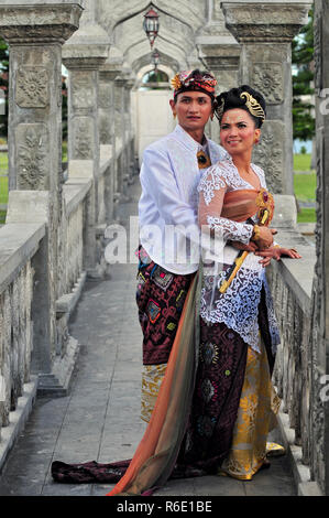 Gli artisti interpreti o esecutori emanazione della scena del matrimonio in preparazione per la cerimonia religiosa in Tirtagangga Taman Ujung acqua Palace Bali, Indonesia Foto Stock
