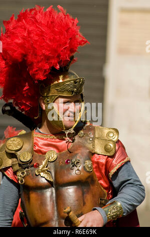 Uomo vestito come un soldato romano, accanto a un militare di Banner, fuori Roma Colosseo, Italia Foto Stock